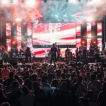An independent musician performing on stage under a spotlight representing the rise of independent artists in the music industry
