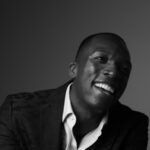 Darshae Kiér smiling in a black-and-white portrait